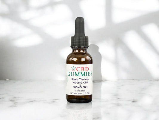 CBD Gummies tincture bottle on a marble surface with a white background